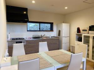cocina con mesa, sillas y nevera en Rental Villa Karuizawa Honors Hill - Vacation STAY 02160v en Oiwake