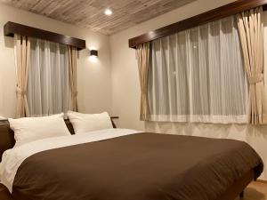 Un dormitorio con una cama grande y una ventana en Rental Villa Karuizawa Honors Hill - Vacation STAY 02160v en Oiwake