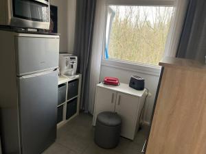 a small kitchen with a microwave and a window at Sarah's Nest in Kerpen