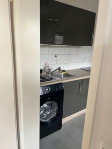 a kitchen with a washing machine and a sink at Sarah's Nest in Kerpen