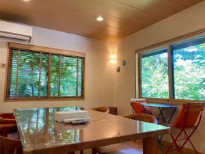 uma sala de conferências com uma mesa, cadeiras e janelas em Rental Villa Karuizawa Honors Hill - Vacation STAY 71491v em Oiwake