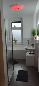 a bathroom with a shower and a sink and a window at Ferienwohnung ASL in Aschersleben