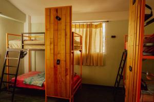 a room with a bunk bed and a room with a ladder at Nopalero Hostel in Puerto Escondido
