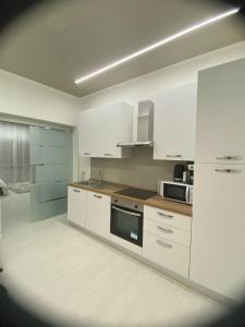 a kitchen with white cabinets and a stove top oven at Appartamento Crihana in Aosta