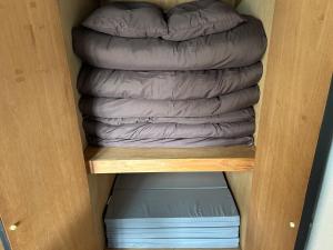 a stack of sleeping bags in a closet at ＴＡＪＩＭＡ ＢＡＳＥ - Vacation STAY 16245 in Fukuoka