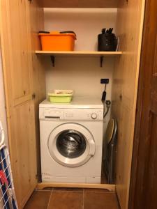uma máquina de lavar e secar roupa num pequeno quarto em DESY'S HOUSE em Oneta