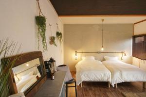 1 dormitorio con 2 camas con sábanas blancas y mesa en Guesthouse Yumi to Ito - Vacation STAY 94562v, en Nagano
