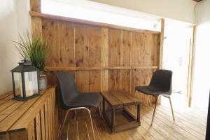 Habitación con 2 sillas y pared de madera. en Guesthouse Yumi to Ito - Vacation STAY 94562v, en Nagano
