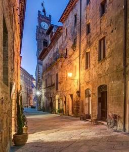 an empty street with a clock tower in the distance at La Casina MAG in Pienza