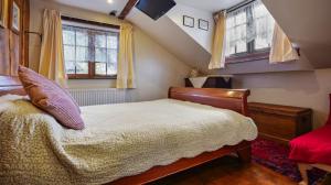 a bedroom with a bed and two windows at Hoots End in Wool