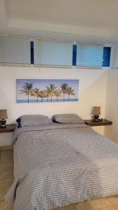 Chichiriviche的住宿－Apartamento tipo estudio，卧室配有一张大床,墙上挂着棕榈树