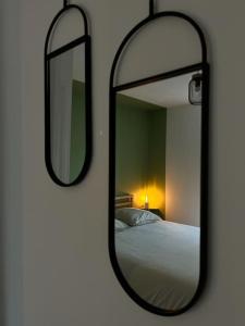 un miroir sur un mur à côté d'un lit dans l'établissement A l’ancienne école, à Saint-Ours