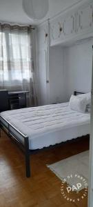 een bed in een kamer met een wit bedframe bij Appartement Val André in Le Port-Marly