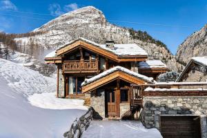a log cabin in the snow with a mountain at Résidence Saint Joseph - Chalets pour 11 Personnes 294 in Val-d'Isère