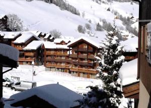a ski lodge in the snow with a tree at VALERIANE G - Appartement VALERIANE 118 pour 4 Personnes 07 in Valmorel