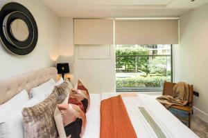 a bedroom with a large bed and a window at HighStreetKen-NewBuilt-AC-HighEnd-HydePark in London
