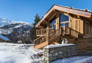a log cabin with a deck in the snow at Résidence Fontany - Chalets pour 12 Personnes 044 in Les Allues