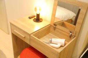 a small wooden cabinet with a mirror and a lamp at [Newly built condominium for rent! ] 5 minutes wal - Vacation STAY 98059v in Tokyo