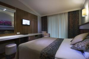 a hotel room with a bed and a flat screen tv at Sun Club Side Hotel - All inclusive in Side