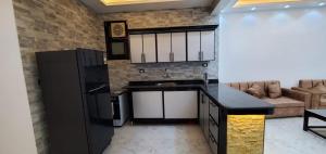 a kitchen with a black refrigerator and a couch at Elminaa Residence 6 in Luxor
