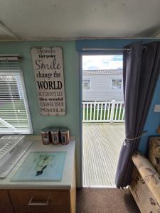 a room with a sliding glass door to a deck at The daxie 3-Bed caravan in Butlins Skegness in Skegness