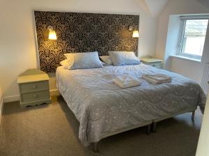 a bedroom with a bed with two towels on it at Marine Terrace Apartments in Criccieth