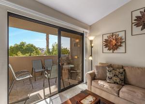 sala de estar con sofá y balcón en Classic Comfort in Central PS - A Ryson Property, en Palm Springs
