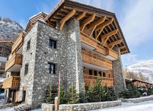 a large building with a wooden roof on top at Résidence Petit Alaska - 5 Pièces pour 8 Personnes 684 in Val-d'Isère