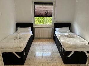 2 camas en una habitación con ventana en Ferienhaus mit Privatparkplatz, Terrasse und Kamin, en Bremen