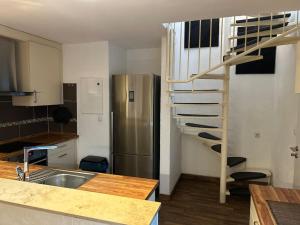 a kitchen with a spiral staircase and a refrigerator at Ferienhaus mit Privatparkplatz, Terrasse und Kamin in Bremen