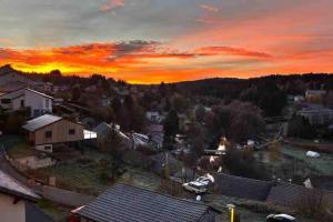 een stad met een zonsondergang op de achtergrond bij Séjour coloré et relaxant in Le Chambon-sur-Lignon