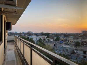 een balkon met uitzicht op de stad bij zonsondergang bij Homey Stays - 2 Bedroom Apartment - Gulberg in Lahore