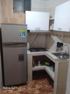 uma pequena cozinha com um frigorífico e um lavatório em Aparta estudio valyval em Ibagué