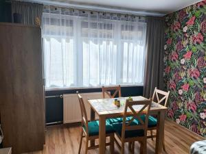 a dining room with a table and chairs and a window at Apartament pod Złotą Małpą in Głuchołazy
