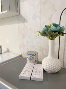 un tavolo con due libri e un vaso con fiori di ЖК «Caspyi Towers», 17-й микрорайон, 3 дом , 2 подъезд, 15 этаж , 114 кв. ad Aqtau