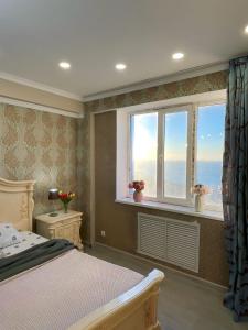een slaapkamer met een bed en een raam met uitzicht bij ЖК «Caspyi Towers», 17-й микрорайон, 3 дом , 2 подъезд, 15 этаж , 114 кв. in Aqtau