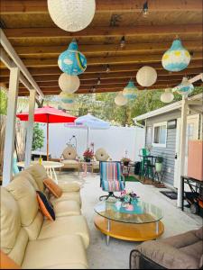 a patio with a couch and tables and umbrellas at Fancy studio private entrance in Selden