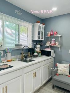 a kitchen with white cabinets and a sink at Fancy studio private entrance in Selden