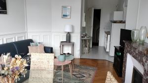 salon z kanapą i stołem w obiekcie Appartement avec belle vue sur la place du Martroi w Orleanie