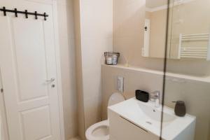 a white bathroom with a toilet and a sink at Apart 53 in Turda