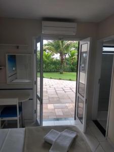 a bedroom with a door open to a patio at Hotel Rota do Sol in Guaratuba