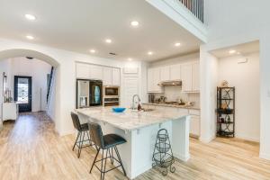 a kitchen with white cabinets and a large island with bar stools at Spacious Royse City Home with Community Pool Access in Royse City