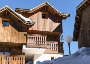 a building with a balcony on the side of it at Résidence LES ALPAGES - Chalet CHALET ALPAGES 19 pour 10 Personnes 08 in Plagne Villages