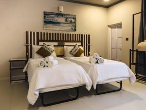 ein Schlafzimmer mit 2 Betten und Handtüchern darauf in der Unterkunft Holiday home in Kamadhoo Island / Maldives in Kamadhoo