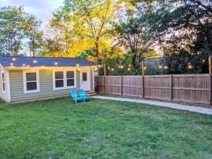 un patio trasero con 2 sillas azules y una valla en Bungalow & Tiny Guest House with Private Fenced Yard, en Charlotte