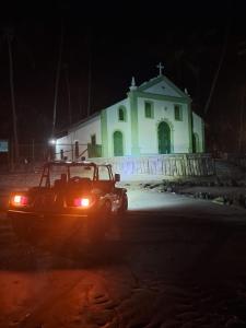 Pousada Dona Felicidade Suítes في تامانداري: سيارة متوقفة أمام كنيسة في الليل