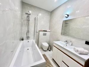 ein Badezimmer mit einer Badewanne, einem WC und einem Waschbecken in der Unterkunft Apartament AirPort Chisinau in Chişinău