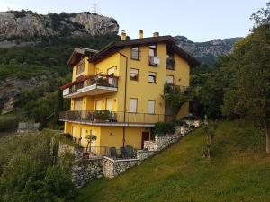 a yellow house on the side of a hill at Appartamenti Nido d'Aquila in Nago-Torbole