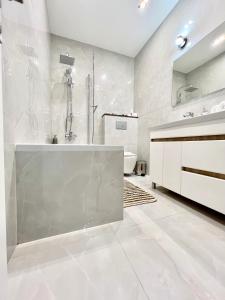 ein weißes Badezimmer mit einer Badewanne und einem Waschbecken in der Unterkunft Apartament AirPort Chisinau in Chişinău