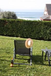 un chapeau assis sur un banc à côté d'une bouteille dans l'établissement Siete Playas Surf House, à Valdoviño